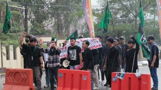 Di bawah guyuran hujan lebat puluhan kader HMI Cabang Sangatta menggelar unjuk rasa di depan Mako Polres Kutim. Sampaikan lima tuntunan. termasuk copot Kapolda Kaltara, Jumat (25/7/2025).