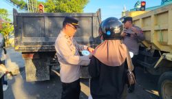 Keterangan: Kapolsek Bontang Selatan, AKP Muhammad Rakib Rais saat membagikan bendera merah-putih ke pengedara motor di Simpang Lampu Merah (Traffic Light), Tanjung Laut.