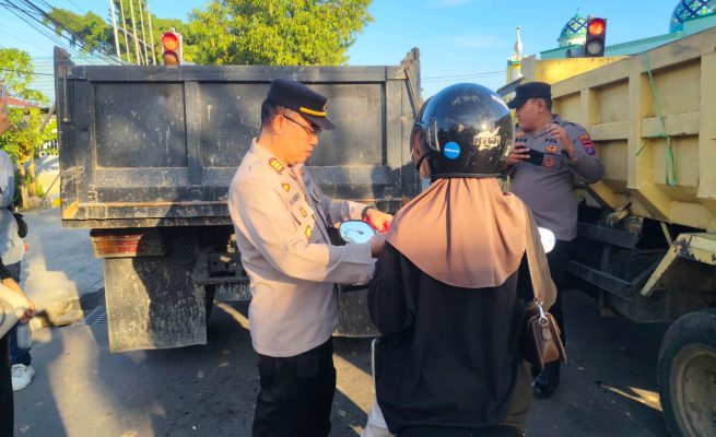 Keterangan: Kapolsek Bontang Selatan, AKP Muhammad Rakib Rais saat membagikan bendera merah-putih ke pengedara motor di Simpang Lampu Merah (Traffic Light), Tanjung Laut.